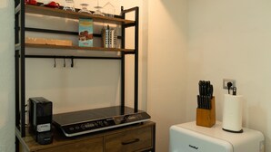Een kitchenette met een koffiezetapparaat, een broodrooster en een messenblok.