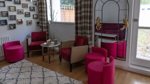En stue med sofa, stole, et lille bord og en dekorativ buet åbning.