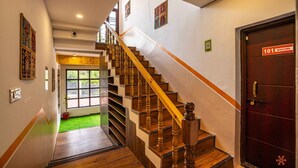 A wooden staircase with a handrail leading to a door marked "101 Martand". - Zostel Pune (Pune)