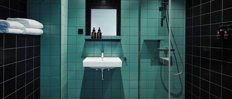 Un baño moderno con lavamanos, espejo y ducha.