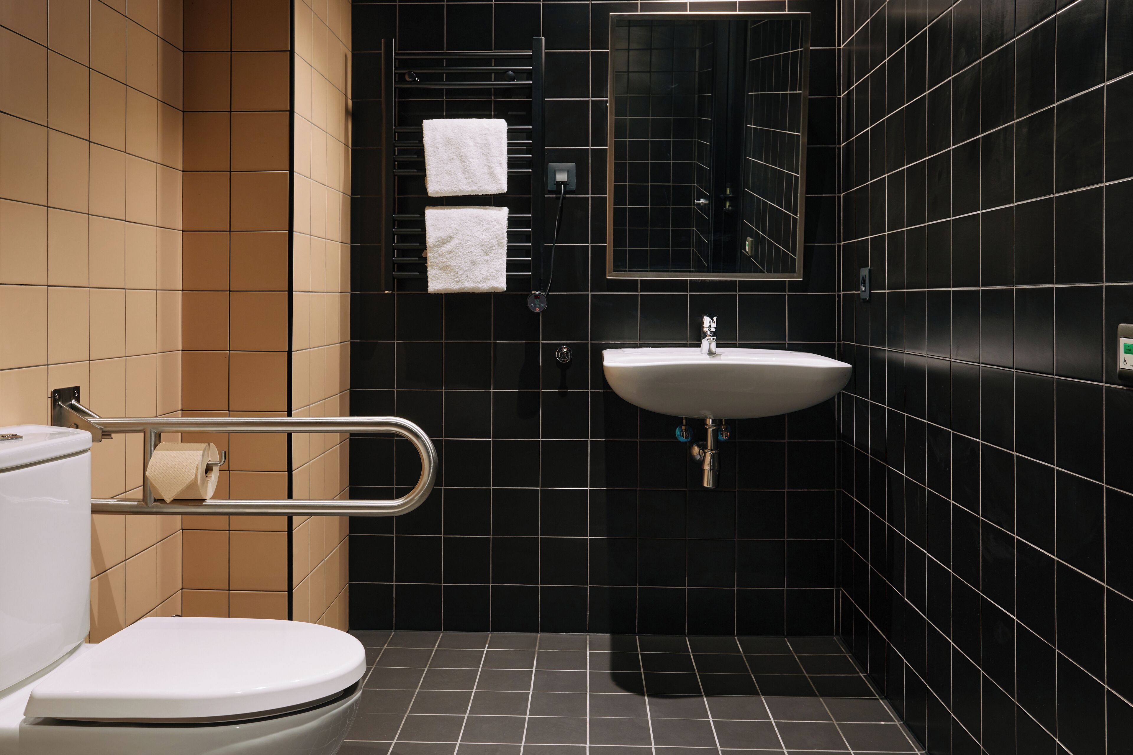 A modern bathroom with a white toilet, a sink, and a mirror.