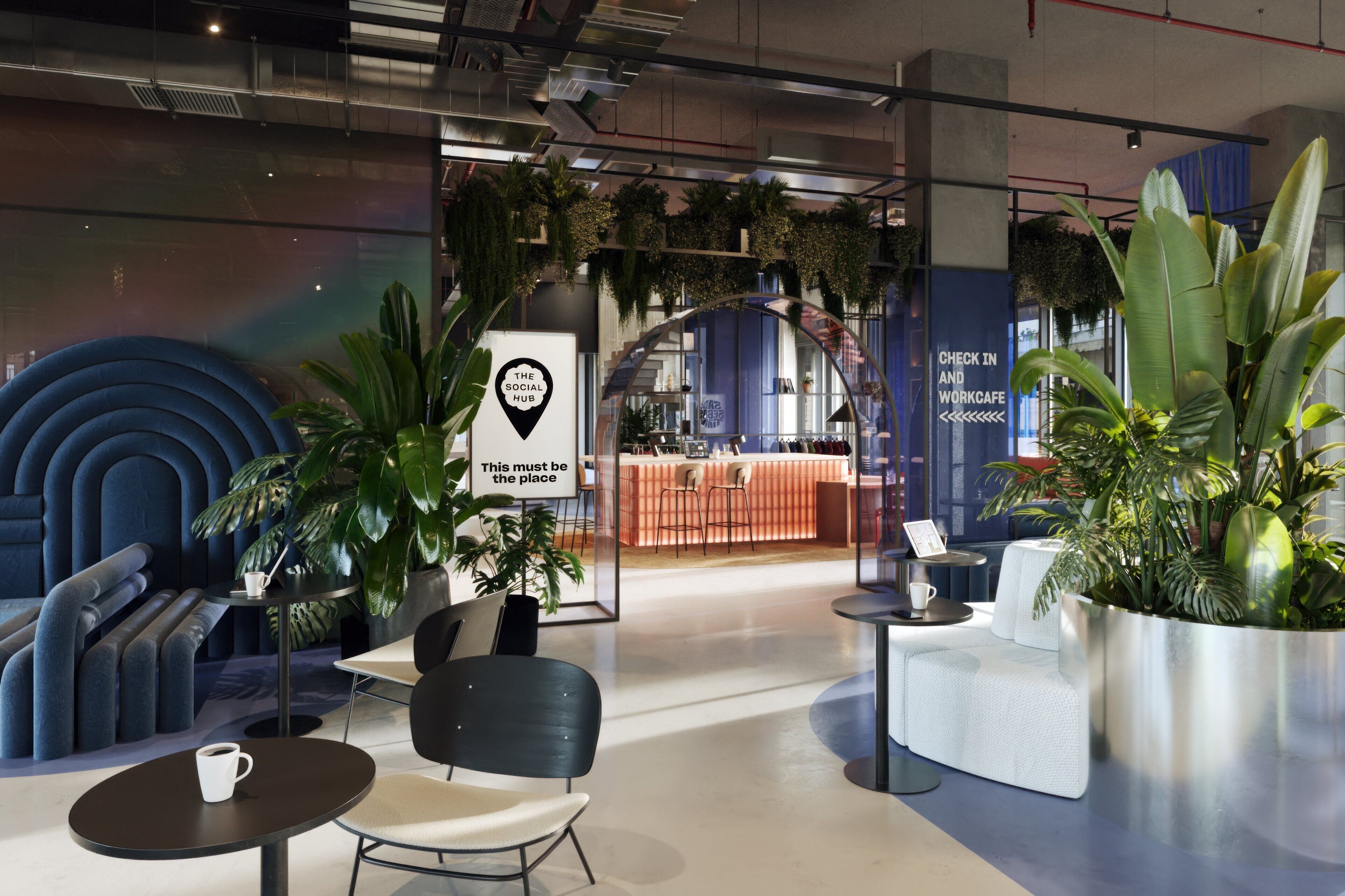 A modern interior with seating areas, a work cafe, and a sign indicating 'The Social Hub'.