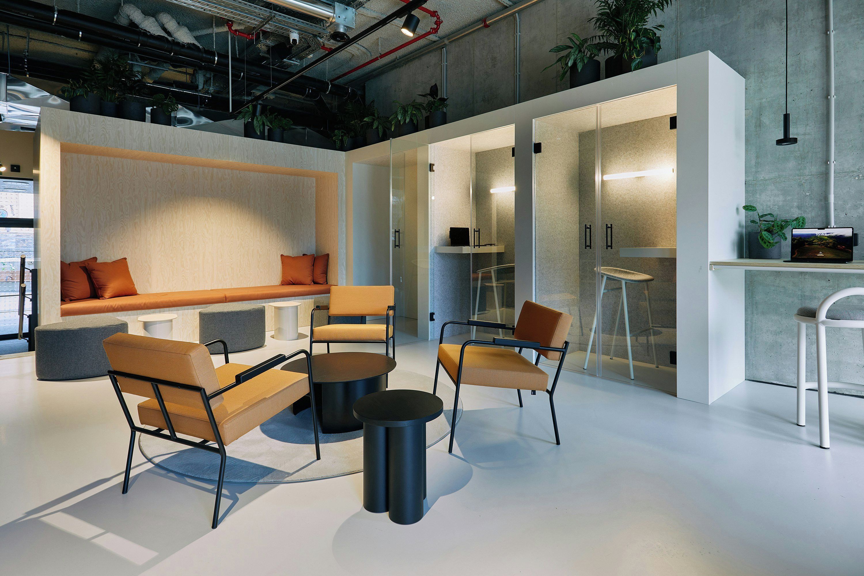 A modern interior with seating, a glass partition, and a bar area.
