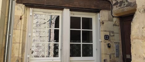 Un bâtiment avec une porte blanche, une petite fenêtre et un panneau indiquant le numéro « 12 ».