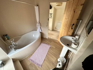 A bathroom with a bathtub, a sink, and a shower. - Beautiful 4-bed Cottage in Heart of the Cotswolds (Witney)
