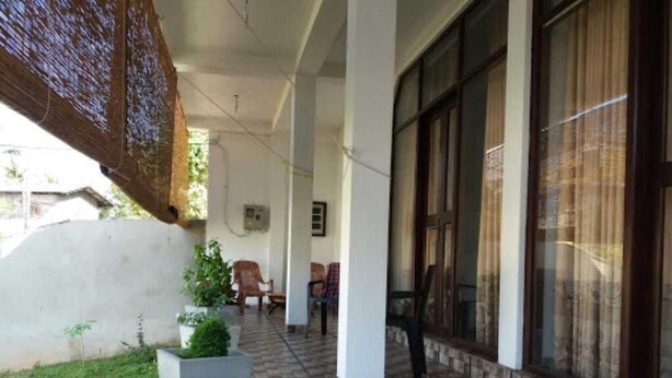 A covered outdoor area with a tiled floor, several chairs, and a potted plant. - Beluga Sands Beach (Ambalangoda)