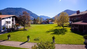 A residential area with houses, a green lawn, and mountains in the background. - Fewo Sonntagshorn Terrasse, Küche, 1 Schlaf- und 1 Wohn-/schlafz., max 5 Pers (Ruhpolding)