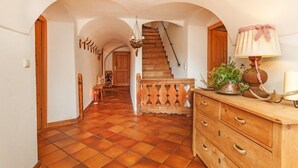 A hallway with a tiled floor, wooden staircase, and a wooden dresser with a lamp and decorative items. - Fewo Sonntagshorn Terrasse, Küche, 1 Schlaf- und 1 Wohn-/schlafz., max 5 Pers (Ruhpolding)