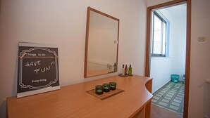 A room with a wooden desk, a mirror, and a motivational poster. There are candles on the desk, and a window with a view of the outside. - Apartments and Room Agata (Medulin)