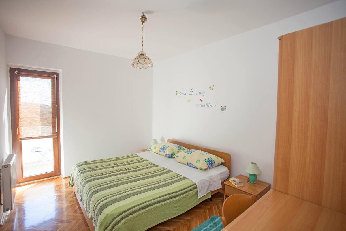 Une chambre à coucher comprenant un lit, une table de chevet, une lampe et un élément décoratif mural.
