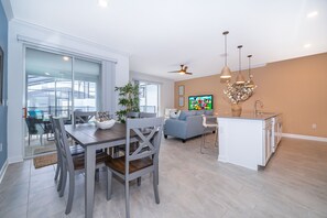 Relax in this open-plan living space with a dining area, sofa, and kitchen.