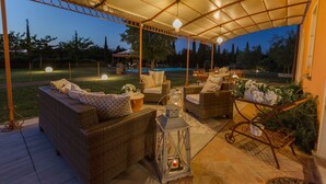 Un espace extérieur aménagé en terrasse, avec des meubles en osier, une lanterne et un panier décoratif.