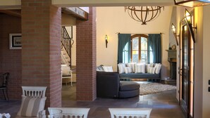Un salon chaleureux avec une cheminée, un canapé et un coin repas avec des chaises.