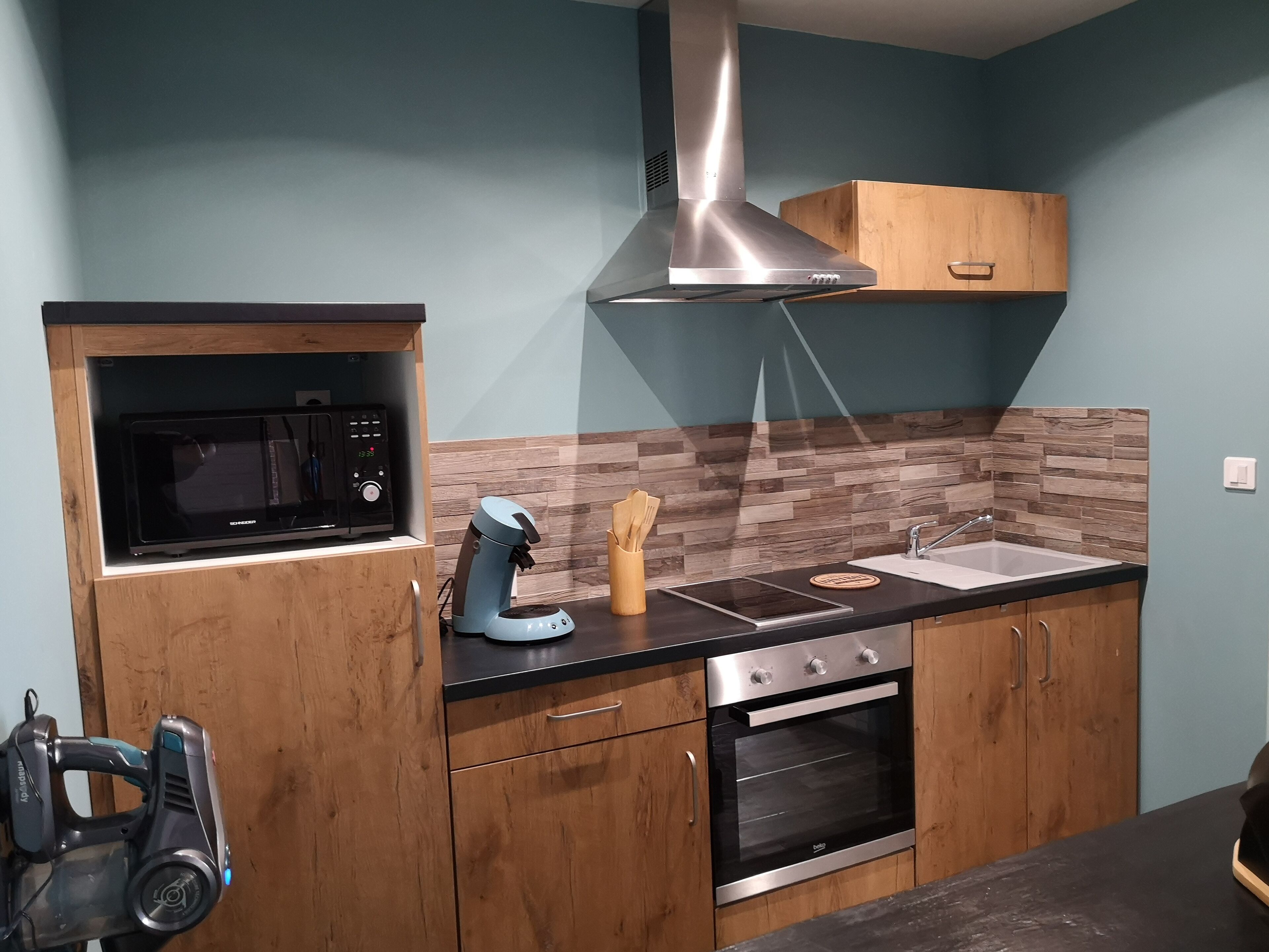 A modern kitchen with a built-in microwave, coffee maker, and oven.