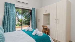 Una habitación de hotel con cama, escritorio y armario.