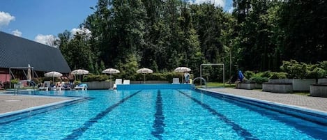 Una piscina techada, una piscina al aire libre de temporada, sombrillas