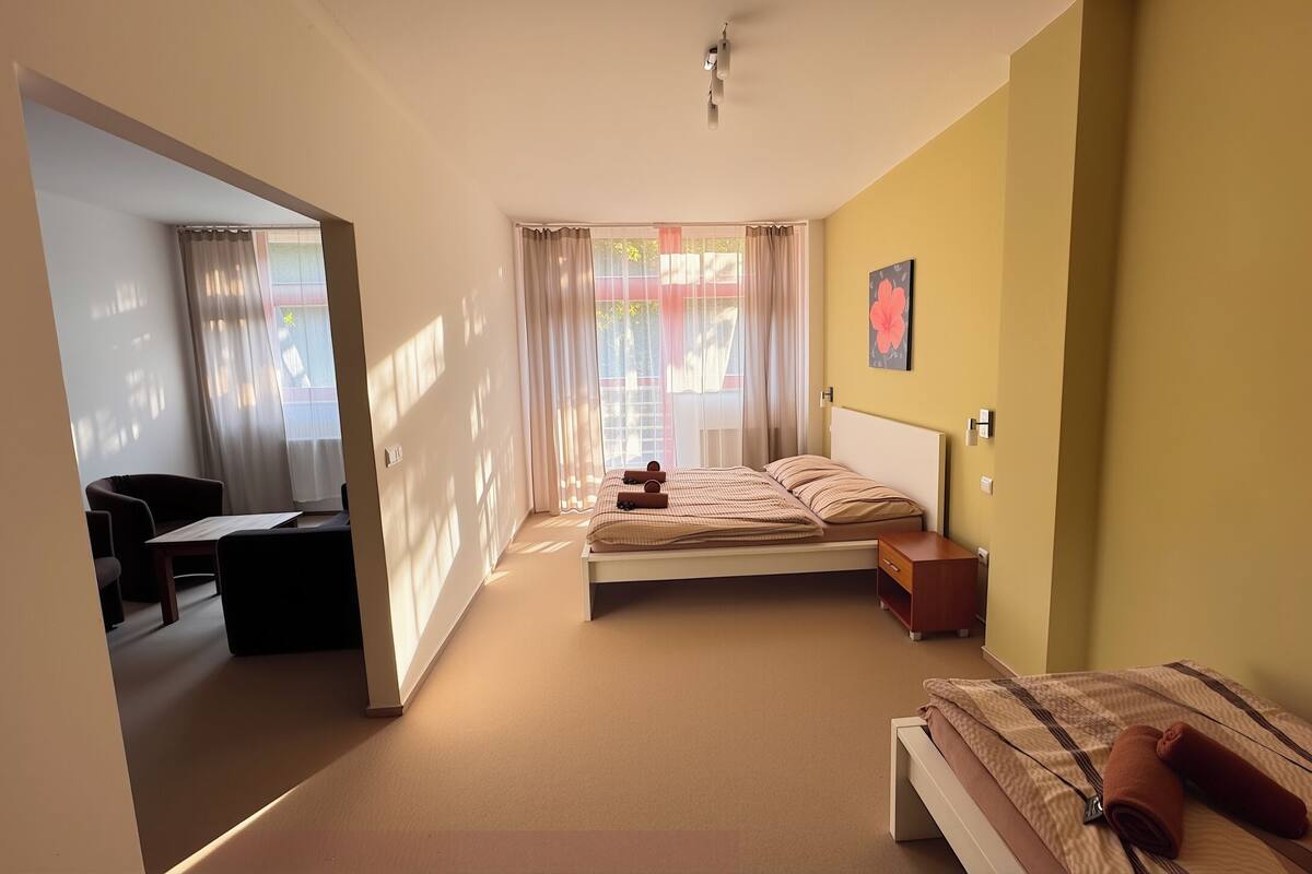 Un dormitorio con cama, mesita de noche y escritorio con silla.