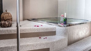 Uma área de spa com hidromassagem, escadas revestidas e abóboras decorativas.