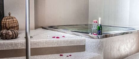 A spa area with a hot tub, tiled steps, and decorative pumpkins.