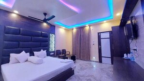 A modern hotel room with a large bed, a desk, and a chair. - Sea Wave Beach Resort (Kanthi)