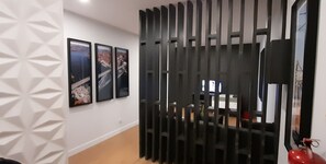 Contemporary space with a geometric patterned wall, flat-screen TV, and room divider.
