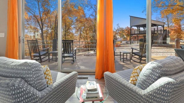 Ein modernes Wohnzimmer mit Glastür, die auf eine Terrasse im Freien führt.