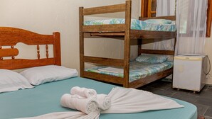 A bunk bed with a wooden headboard, a small white refrigerator, and a teal bedspread. - Pousada Chalé do Beija-flor  (Ubatuba)