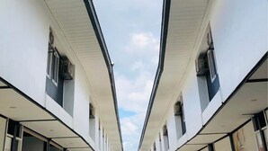 Un pasillo de diseño simétrico, con un camino central flanqueado por habitaciones idénticas a ambos lados.
