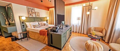 Una habitación de hotel moderna con cama, escritorio, sofá y zona de comedor.