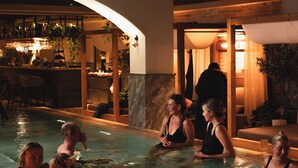 A heated indoor swimming pool with people relaxing and socializing. - Hotel Fratelli (Karlstad)