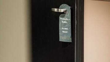A hotel room door with a sign that reads "Sleeping like a baby. Do not disturb."