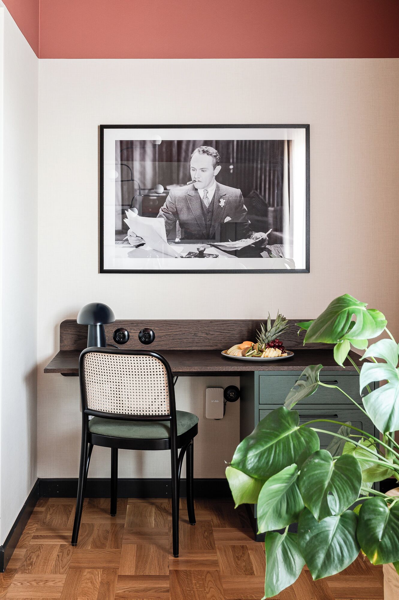 Un espacio de oficina moderno con un escritorio, una silla y una fotografía grande en el marco en la pared.
