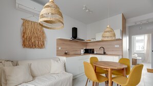 A modern kitchen with a wooden countertop, a built-in stove, and a hanging light fixture.