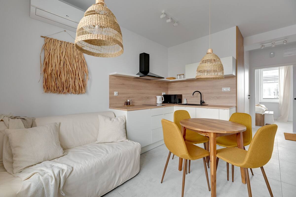 Een moderne keuken met een houten aanrechtblad, een inbouwfornuis en een hanglamp.