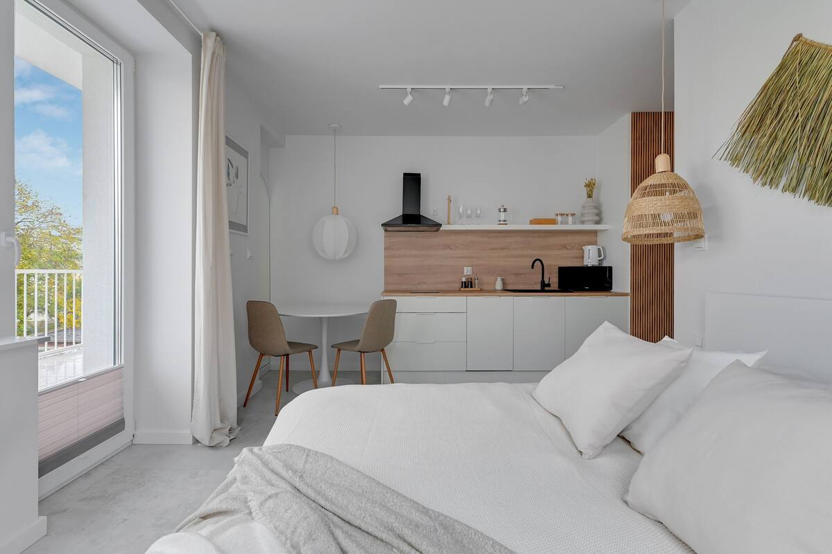 Een moderne hotelkamer met een groot bed, een zithoek en een keuken.