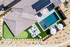 Eine Vogelperspektive eines Grundstücks mit Schwimmbad, Sitzgelegenheiten im Freien und Solaranlage.