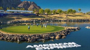 A golf course with a pond, a mountain in the background, and the text 'AMERICAN EXFAMILY' on the water.