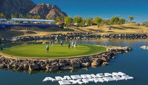 A golf course with a pond, a mountain in the background, and the text 'AMERICAN EXFAMILY' on the water.