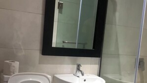 Un bagno con il water, un lavandino e una cabina doccia in vetro.