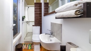 Une petite salle de bain comprenant des toilettes, un lavabo et une douche.