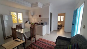A compact living space with a kitchenette, a dining area, and a bedroom. - Cozi Coliving (Mezraia)