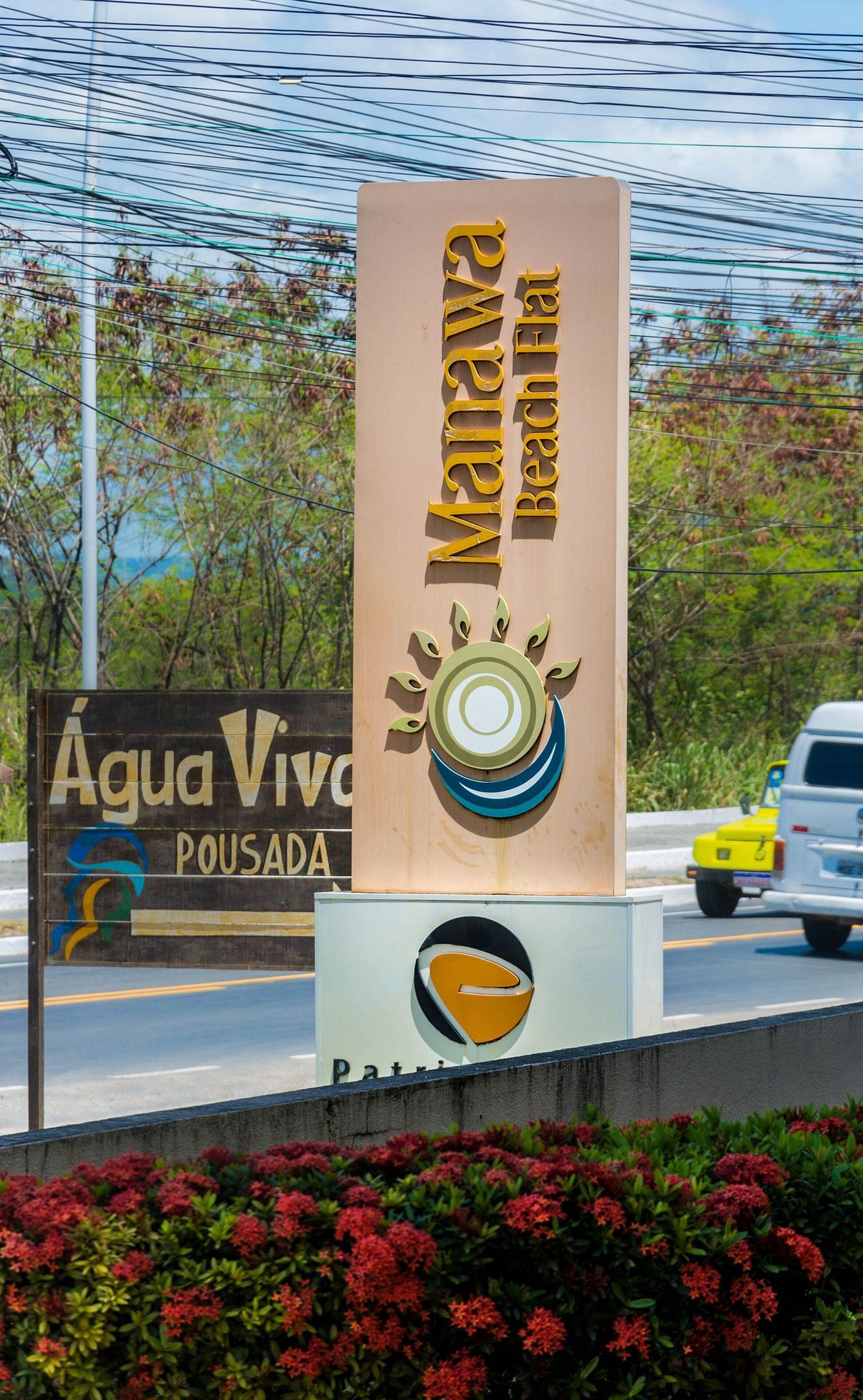 Un cartel para la Playa Marava con un diseño de sol, un logo y un anuncio para la Pousada Agua Viva.
