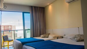 A hotel room with two beds, a balcony with a chair, and a large window. - Manawa Beach Flat by All (Ipojuca)