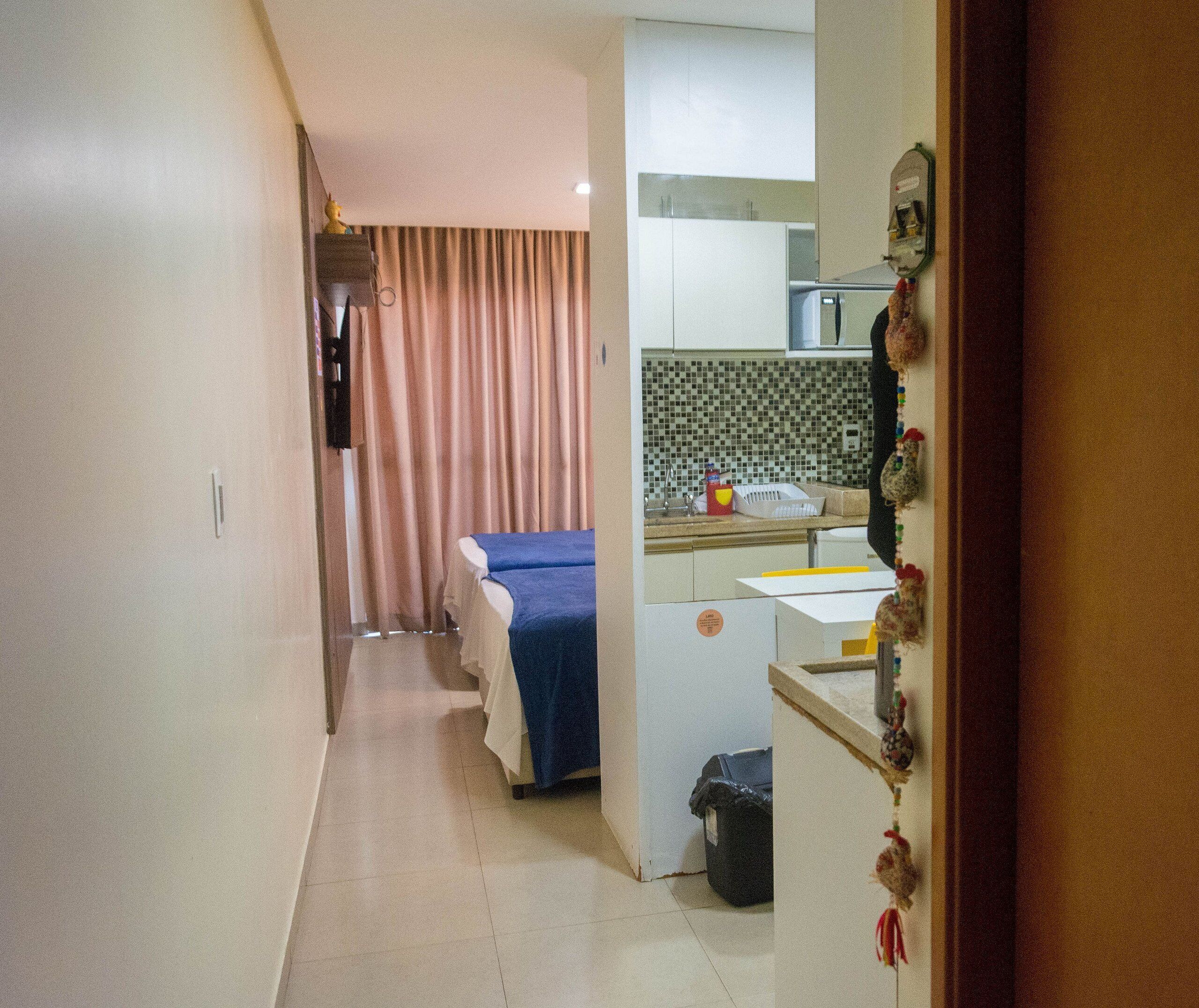 Una habitación de hotel con cama, kitchenette y baño.