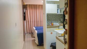 Una habitación de hotel con cama, kitchenette y baño.