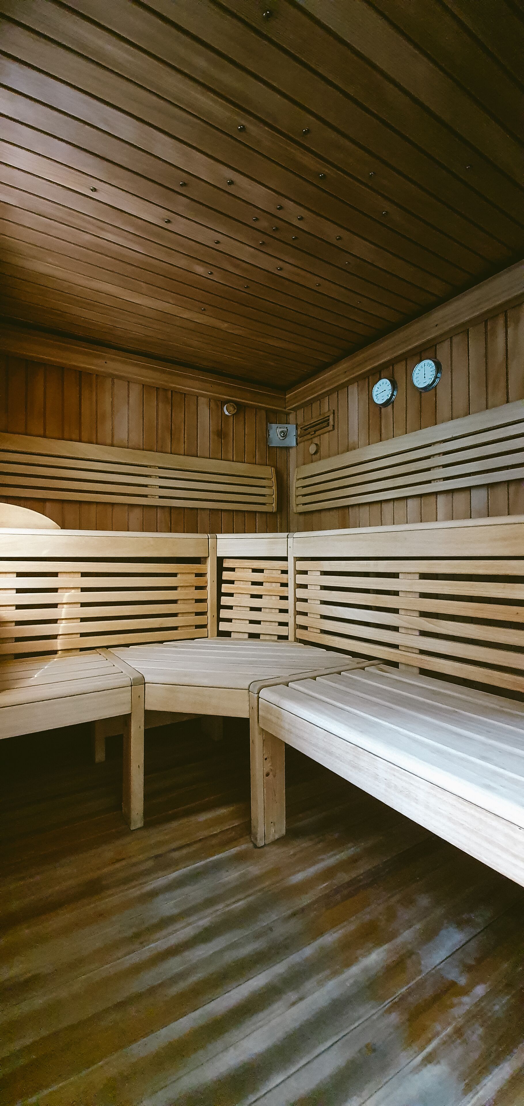 Un sauna avec des bancs en bois et un plafond incliné.