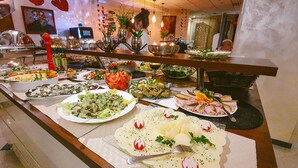 Un bufé con diversos platos y un barman en la barra.