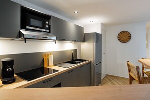 A modern kitchen with a Bosch microwave, a coffee maker, and a sink.