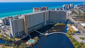 A large hotel with multiple high-rise buildings, a central courtyard pool, and a view of the ocean. - Ocean View-Gym-Pools-Restaurants - LTW 1517 (Panama City Beach)