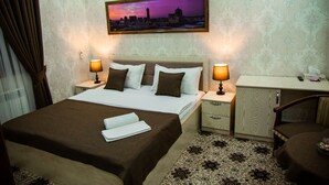 Een hotelkamer met een bed, twee nachtkastjes, een bureau en een stoel.